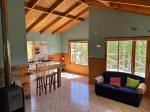 a living room with a couch and a kitchen at Cabañas Don Lino in Cochrane