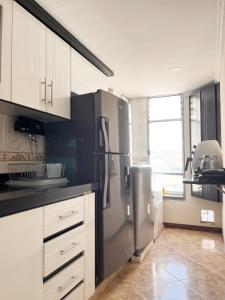 a kitchen with a stainless steel refrigerator and white cabinets at Macadamia Apartamento 201 in Tunja