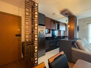 a kitchen with a refrigerator and a table in a room at Apto 407 Torre 4 Vila II in Barra Velha