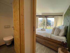 sypialnia z dużym łóżkiem i oknem w obiekcie Les Trois Chaufatons - Chalets Boutiques w mieście Montriond