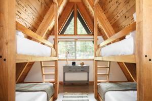 two bunk beds in a room with a window at Timberline by AvantStay Stunning Chalet Cabin w Hot Tub Pool Table Home Theater in Tahoe Vista