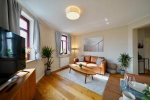 a living room with a couch and a table at EDLER WOHNRAUM Noble Stadtoase mit Boxspringbett, Kaffeevollautomat & Parkplatz in Zwickau +27 photos