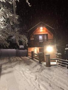 uma cabana de madeira na neve à noite em Likani house em Borjomi