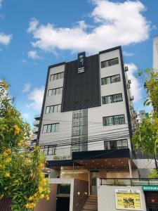 a tall white building with a sign on it at Hotel Gogó da Ema in Maceió