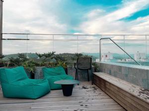 a balcony with green pillows and a table on a roof at Loft Studio com Piscina em Blumenau ZW3837 in Blumenau