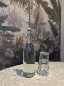 a glass bottle sitting on a table next to a glass at Guesthouse de Loft in Bruges