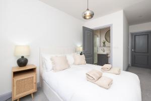 a bedroom with a white bed with towels on it at Bath Street Penthouse in Bath