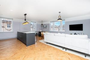 a living room with a white couch and a tv at Bath Street Penthouse in Bath