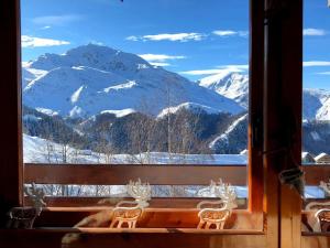 a view of a snowy mountain from a window at Residence i Larici in Prato Nevoso