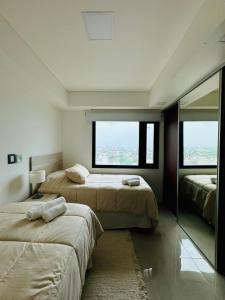 two beds in a room with two windows at Edificio Guay I in Concepción del Uruguay