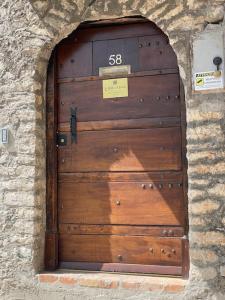 a large wooden door in a stone wall at Stalla suite con living esterno vista mozzafiato in Norma