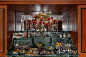 a buffet filled with food and a vase of flowers at La Chambre du Marais in Paris