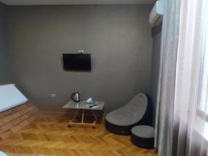a room with a table and a chair and a television at MariElla in Akhaltsikhe