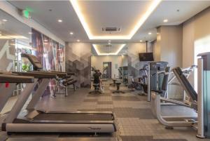 a gym with cardio equipment and a person on a treadmill at CC Loft in Mandurriao