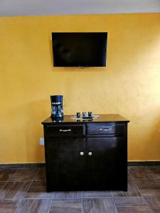 a bathroom with a sink and a flat screen tv at Sensity home Casa Flores, Hogareña y encantadora in Tehuacán