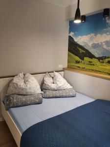 a bedroom with two pillows on a bed with a painting at Apartament Turkusowy in Karpacz