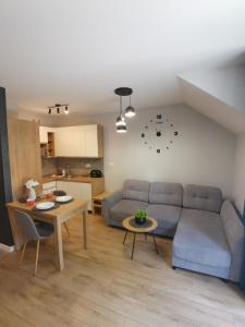 a living room with a couch and a table at Apartament Turkusowy in Karpacz