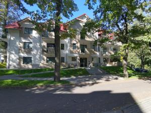 a large white building with trees in front of it at Apartament Turkusowy in Karpacz