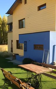 a picnic table in front of a house at Casa Lego in Dina Huapi
