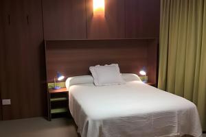a bedroom with a large bed with a white blanket at Casa Lego in Dina Huapi