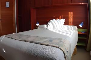 a bedroom with a white bed with a wooden headboard at Casa Lego in Dina Huapi