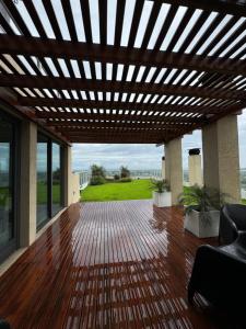 a patio with a wooden deck with a pergola at Edificio Guay I in Concepción del Uruguay