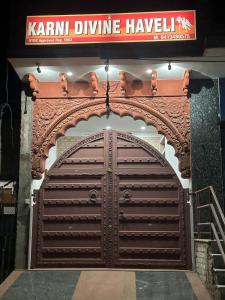 una gran puerta de garaje de madera frente a un edificio en Karni Divine Haveli, en Bikaner
