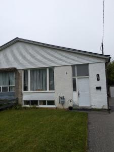 a white house with a lawn in front of it at Multiple Fair Price Great Amenities Rooms in Richmond Hill +26 photos