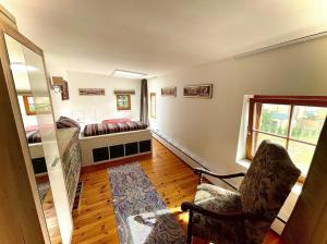 a room with a bedroom with a bed and a chair at Historisches Retro Loft 70m2 mit Garten & Seenähe in Schwielowsee