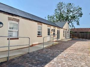 een gebouw met een bakstenen loopbrug ervoor bij The Royal Oak Cottages in Hunmanby