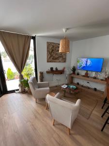 a living room with white furniture and a flat screen tv at Papá Totë Deluxe in Playa Honda