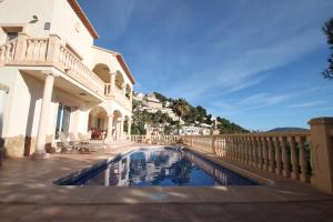 a swimming pool in front of a house at Mimo - sea view villa with private pool in Moraira-Teulada in Moraira