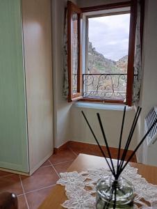 a vase sitting on a table in front of a window at La casetta di Anna in Villalago