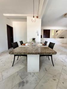 a dining room with a marble table and chairs at Casa Mar Arraial d'Ajuda in Arraial d'Ajuda