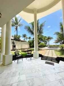 a patio with two benches and palm trees at Casa Mar Arraial d'Ajuda in Arraial d'Ajuda