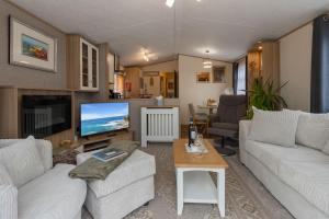 a living room with two white couches and a television at Lake View Holiday Home - Fishing Lakes, Heated Outdoor Swimming Pool 500yrds on Sister Park, Pool Shut for the winter open April 2026 in Exeter