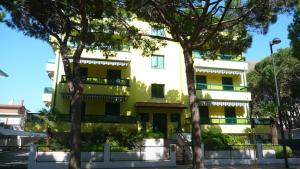 un edificio con árboles delante de él en Residence Pineta - Agenzia Cocal, en Caorle