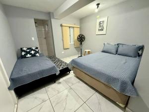 Casa na Vila No coração Gonzaga في سانتوس: غرفة نوم بسريرين ومروحة