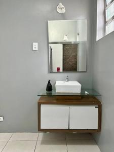 Casa na Vila No coração Gonzaga في سانتوس: حمام مزود بحوض ومِرآة