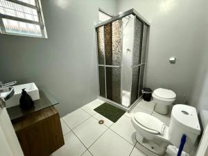 Casa na Vila No coração Gonzaga في سانتوس: حمام ابيض مع مرحاض ودش +18 صورة