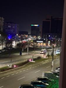 a city at night with cars parked on the street at Lucas Apartament in Craiova +1 photo