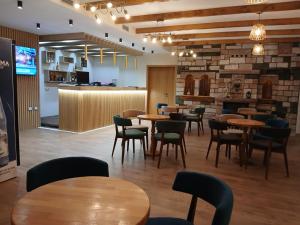 a restaurant with tables and chairs and a bar at Bujtina Çupa in Klos