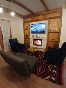 a living room with a fireplace and a tv at Bujtina Çupa in Klos