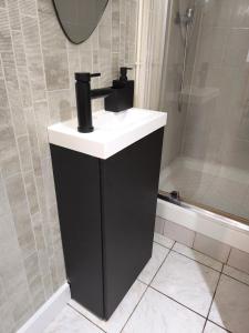 a bathroom with a black and white sink and a shower at Magnifique T2 Centre Ville in Le Havre