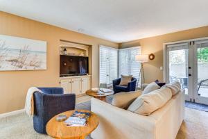 un salon avec un canapé, des chaises et une télévision dans l'établissement Resort Perks Beach Access Condo in Hilton Head, à Île de Hilton-Head