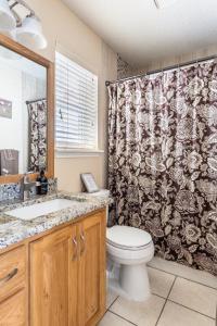 a bathroom with a toilet and a shower curtain at Cozy 3BR Retreat with Outdoor Dining & BBQ Grill in Pflugerville +13 photos