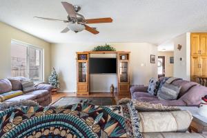 a living room with couches and a flat screen tv at Cozy 3BR Retreat with Outdoor Dining & BBQ Grill in Pflugerville