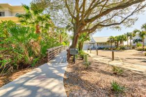 un trottoir avec un panneau à côté d'un arbre dans l'établissement Resort Perks Beach Access Condo in Hilton Head, à Île de Hilton-Head