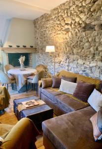 ein Wohnzimmer mit einer Couch und einer Steinwand in der Unterkunft Nichoir des gorges in Montolieu