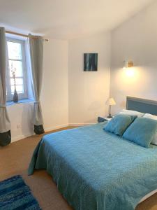 ein Schlafzimmer mit einem blauen Bett und einem Fenster in der Unterkunft Nichoir des gorges in Montolieu